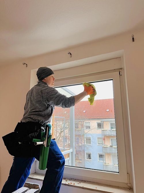Ein-Fensterputzer-in-Nuernberg-reinigt-mit-einem-Tuch-eine-Fensterscheibe.
