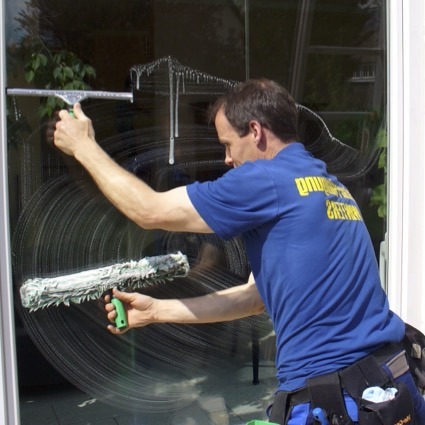 erfahrener-Fensterputzer-putzt-ein-grosses-Fenster